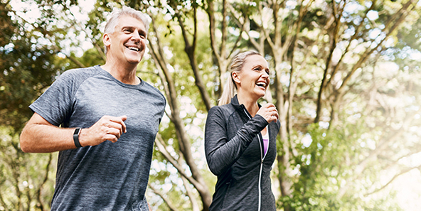 Couple Who Just Chose Their Medicare Plan Jogging Through The Trees