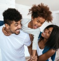 Couple And Daughter Smiling Because They Are Covered By Family Health Plan