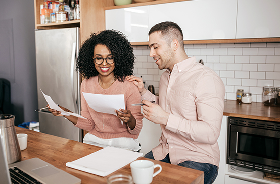 Smiling couple with a laptop taking advantage of their IBX member benefits