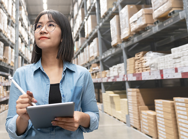 Employee With A Tailored Health Plan In Warehouse Holding Clipboard