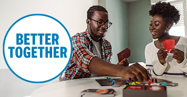 A couple is having a conversation at a dining room table.