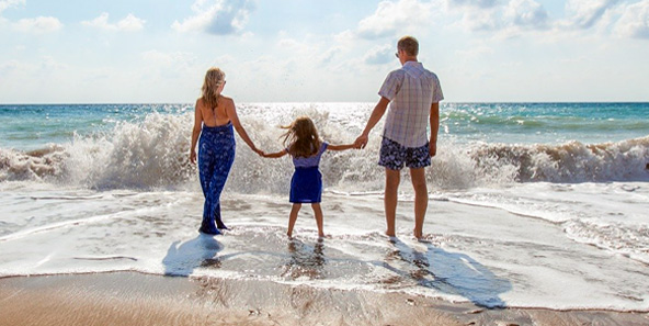 Padres en la playa con un niño cubierto por el plan Keystone HMO Chip