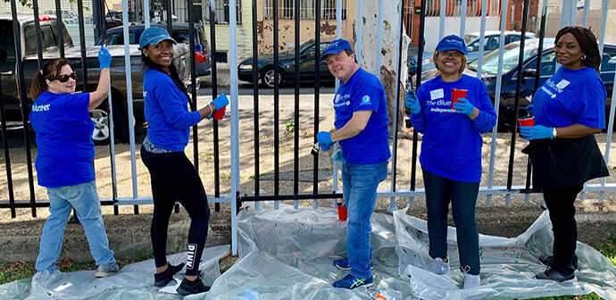 Blue Crew Volunteers Smiling While Painting