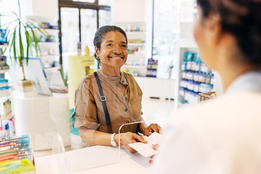 Woman picking up medication at the pharmacy.
