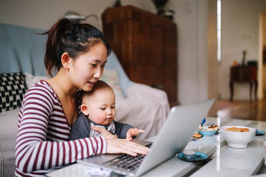 Woman working while holding baby