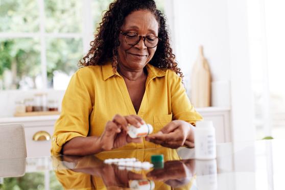 Woman filling a daily pill organizer.