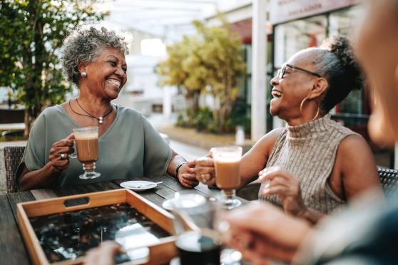 Two senior women out for coffee and laughing