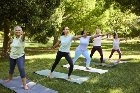 Group of older women doing yoga in the park