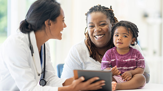 A doctor goes over test results with a woman and her baby