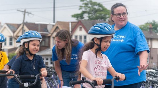 Blue Crew volunteers work with kids at Graduation on Wheels.