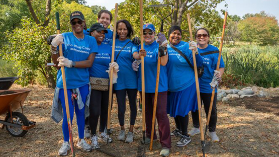 Volunteers making food at a barbecue.