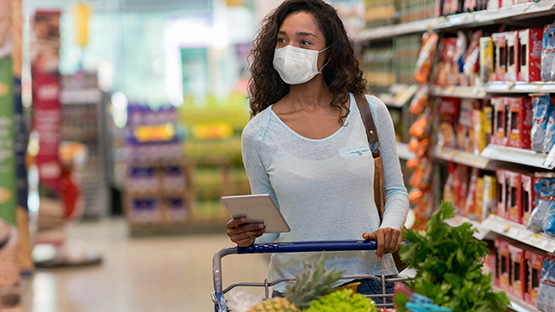 Mujer con máscara va de compras después de recibir la vacuna COVID-19