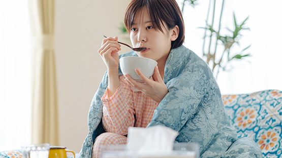 A Woman Eats Soup To Help Her Recover From The Flu